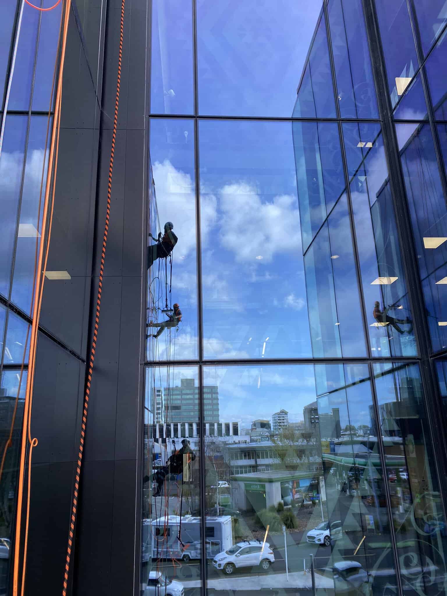 Workers cleaning the side of a building via rope access