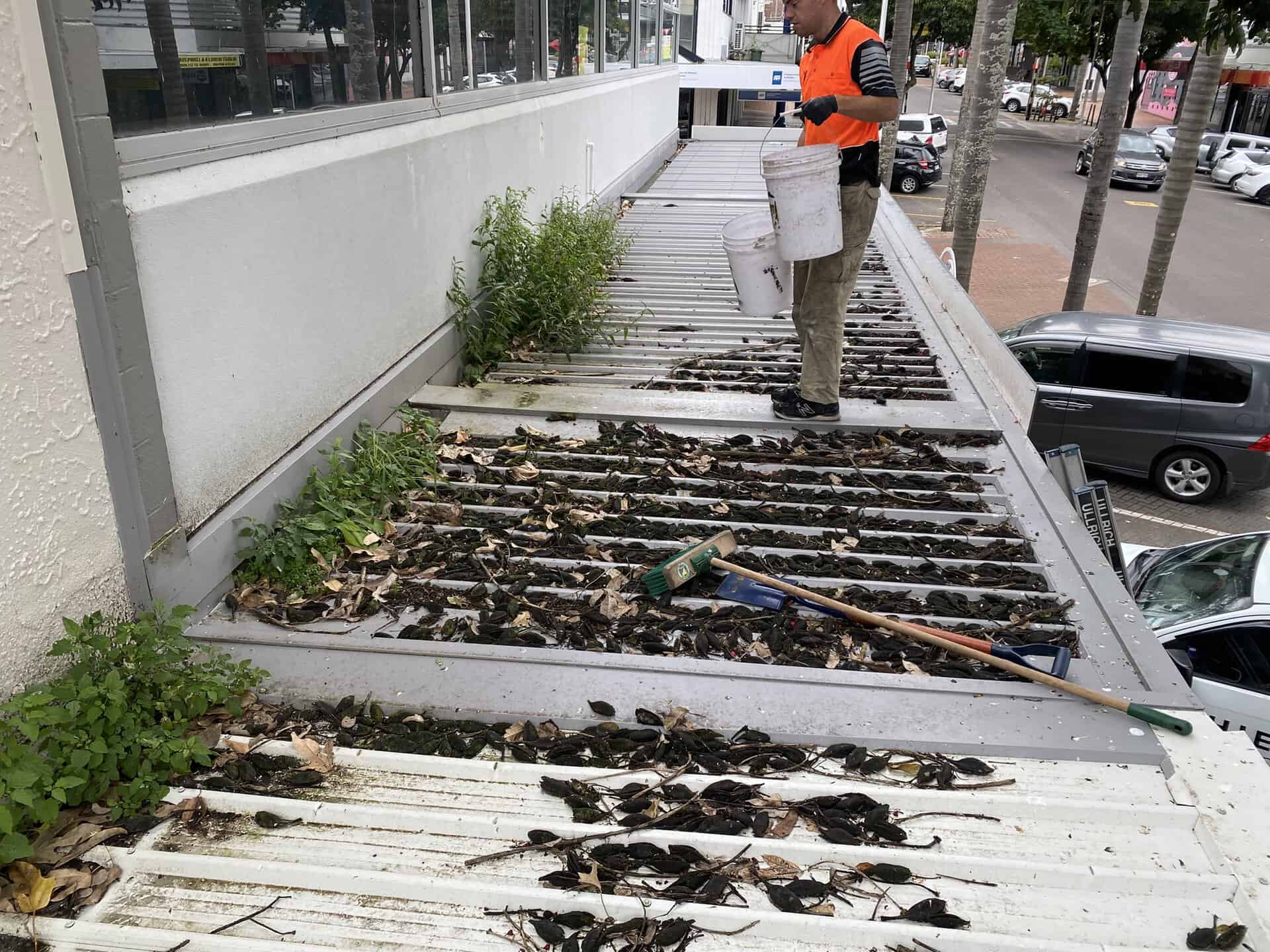 Worker cleaning debris from a roof